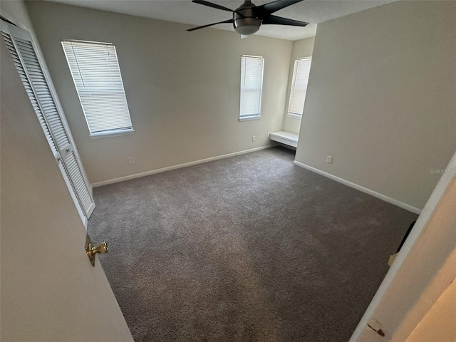 carpeted spare room featuring ceiling fan