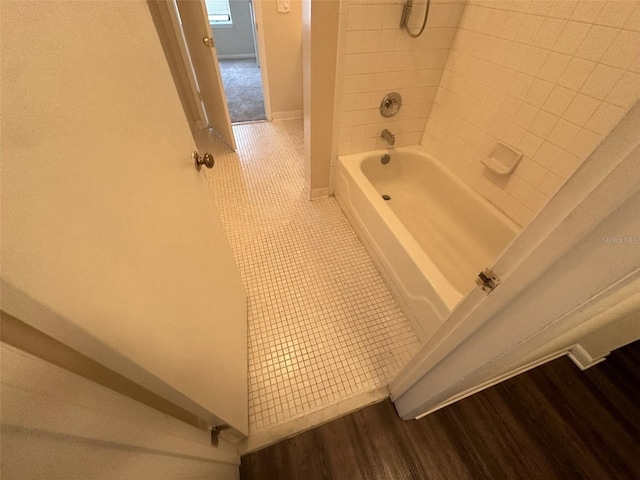 bathroom with tiled shower / bath combo and hardwood / wood-style floors