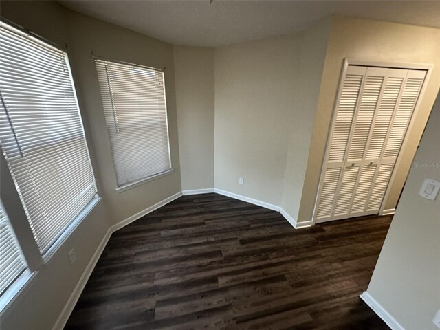 unfurnished bedroom featuring a closet and dark hardwood / wood-style floors