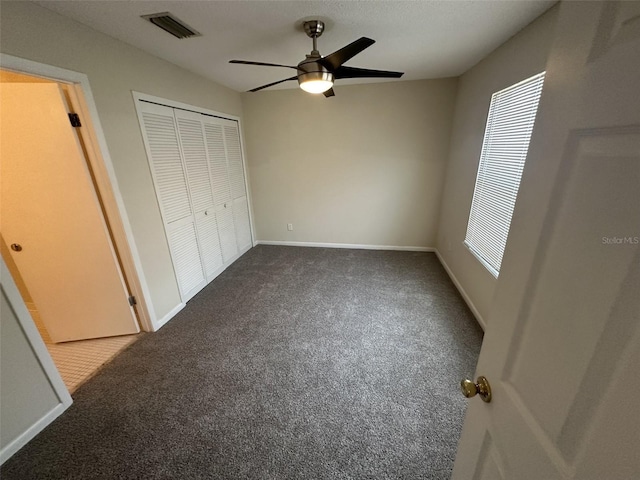 unfurnished bedroom featuring ceiling fan, a closet, and carpet floors