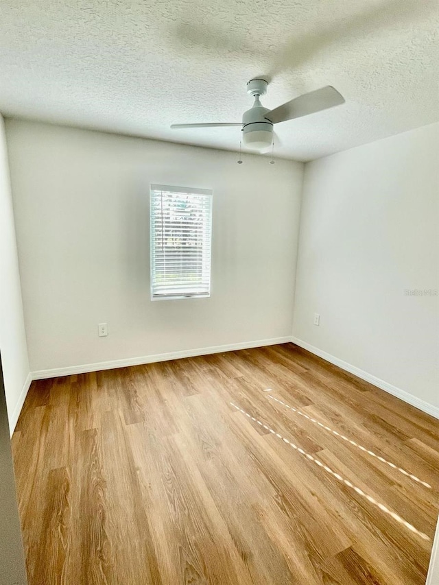 unfurnished room featuring wood-type flooring, a textured ceiling, and ceiling fan