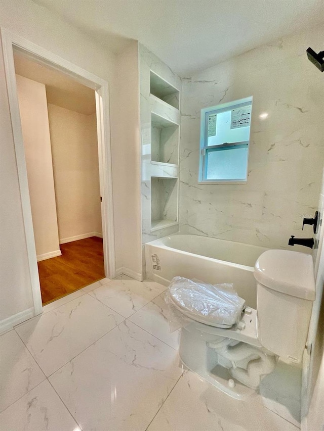 bathroom featuring wood-type flooring, shower / bath combination, and toilet