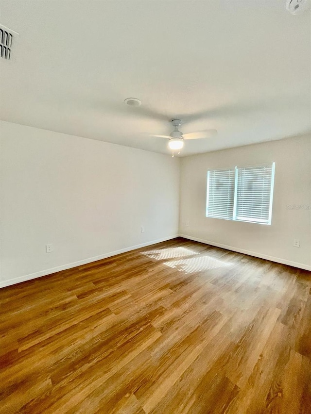 empty room with hardwood / wood-style floors and ceiling fan