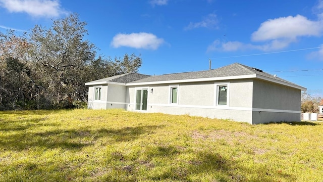 rear view of house featuring a lawn