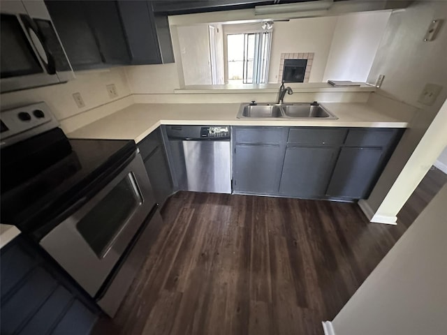 kitchen with sink, stainless steel appliances, dark hardwood / wood-style flooring, and gray cabinetry