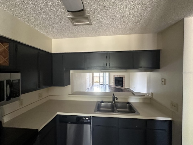 kitchen featuring a textured ceiling, sink, and stainless steel appliances