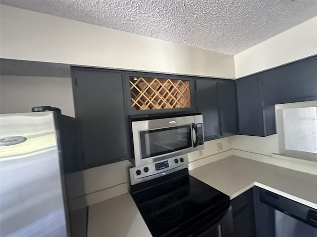 kitchen with appliances with stainless steel finishes and a textured ceiling