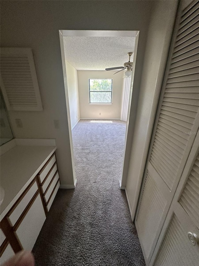 hallway featuring carpet floors and a textured ceiling