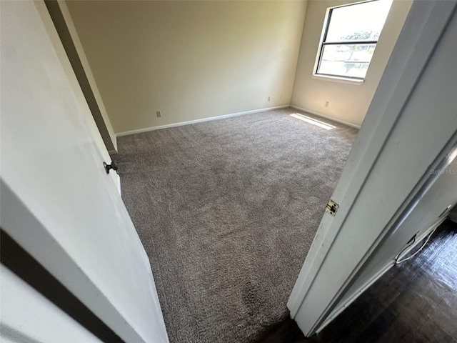 spare room with dark colored carpet