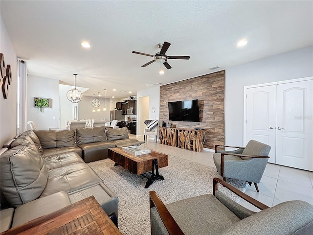 tiled living room featuring ceiling fan with notable chandelier and a textured ceiling