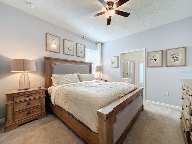 carpeted bedroom with ceiling fan, ensuite bath, and a textured ceiling