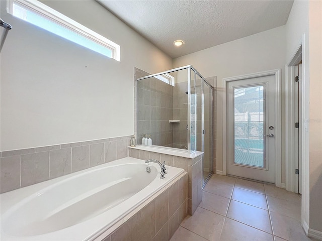 bathroom with plenty of natural light, tile flooring, independent shower and bath, and a textured ceiling