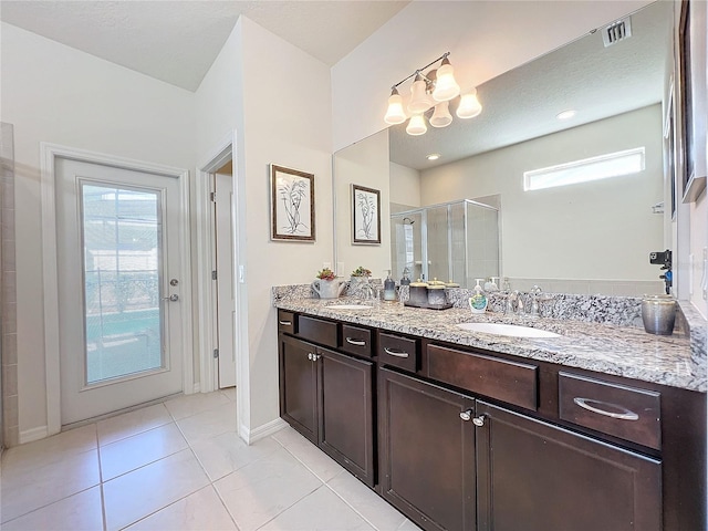 bathroom featuring a wealth of natural light, dual bowl vanity, and tile flooring