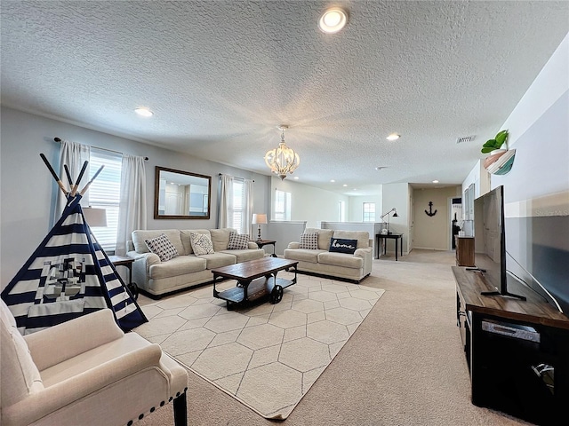 living room with light carpet, an inviting chandelier, and a textured ceiling