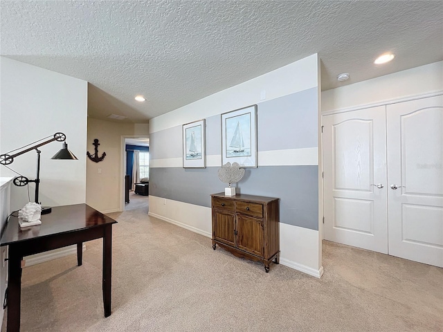 home office with light colored carpet and a textured ceiling