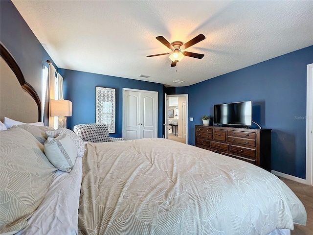 bedroom with a closet, ceiling fan, carpet, and a textured ceiling