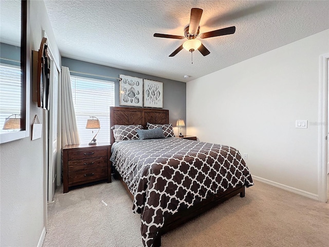 carpeted bedroom featuring a textured ceiling and ceiling fan