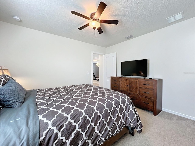 carpeted bedroom with ceiling fan and a textured ceiling