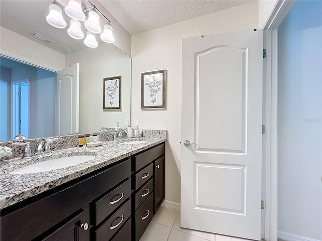 bathroom with large vanity, a textured ceiling, tile floors, a chandelier, and dual sinks