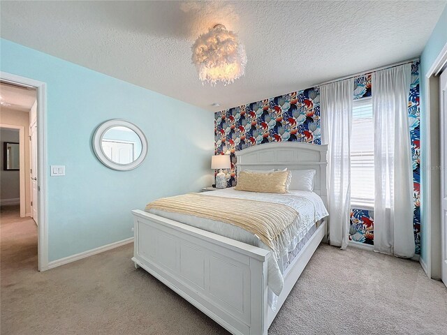 bedroom with light carpet and a textured ceiling