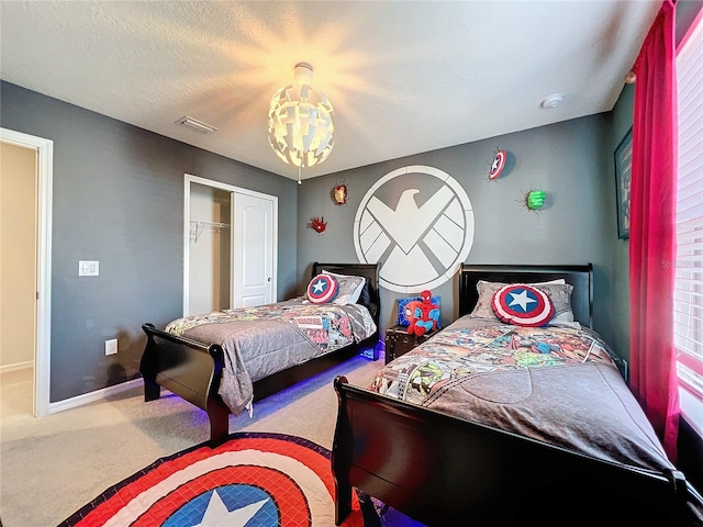 bedroom with a closet, an inviting chandelier, and carpet flooring