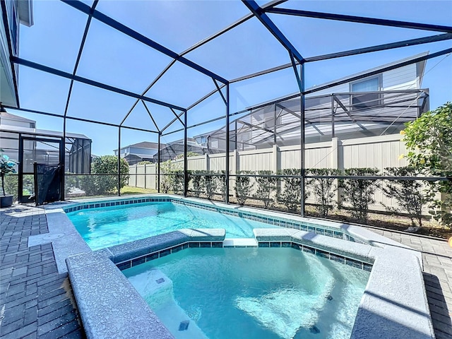 view of swimming pool featuring an in ground hot tub and glass enclosure