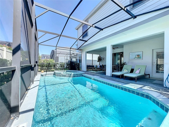 view of pool with a patio area, an in ground hot tub, and glass enclosure