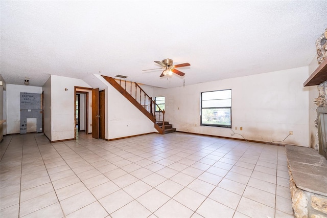 unfurnished living room featuring light tile patterned floors, a textured ceiling, and ceiling fan