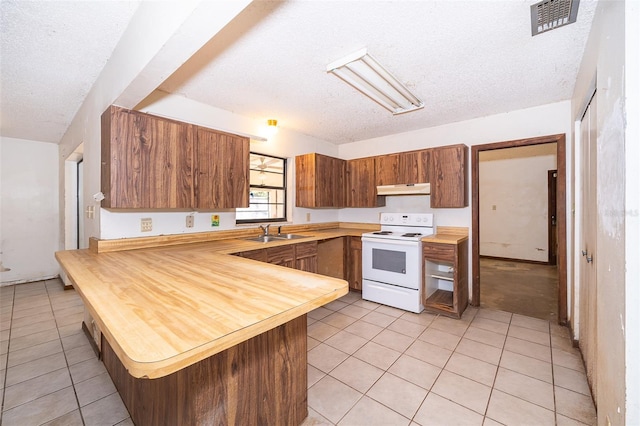 kitchen with sink, light tile patterned flooring, white range with electric cooktop, and kitchen peninsula