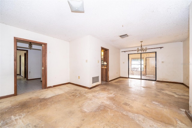 empty room with tile patterned floors, a notable chandelier, and a textured ceiling