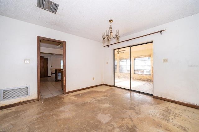 unfurnished room featuring concrete floors, an inviting chandelier, and a textured ceiling