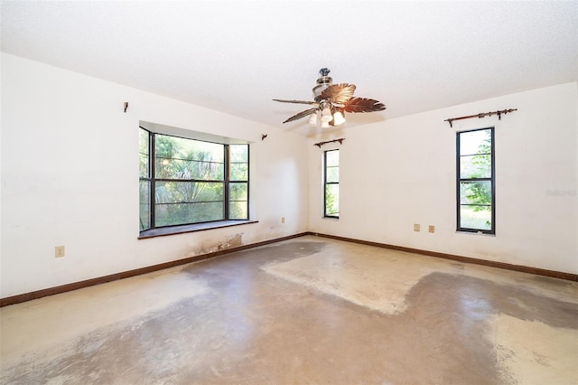 unfurnished room with concrete floors, a healthy amount of sunlight, ceiling fan, and a textured ceiling