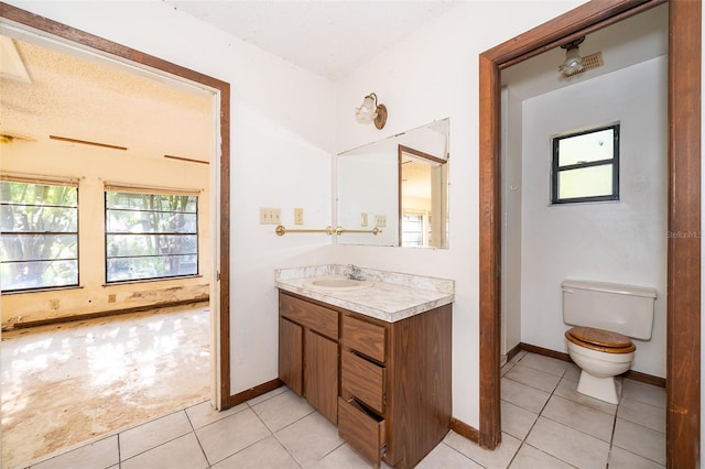 bathroom with tile patterned flooring, toilet, vanity, and a textured ceiling