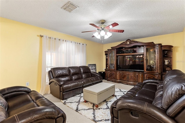 living room featuring light colored carpet, ceiling fan, and a textured ceiling