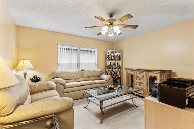 living room featuring a textured ceiling, ceiling fan, and carpet