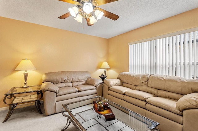 living room with carpet, ceiling fan, and a textured ceiling