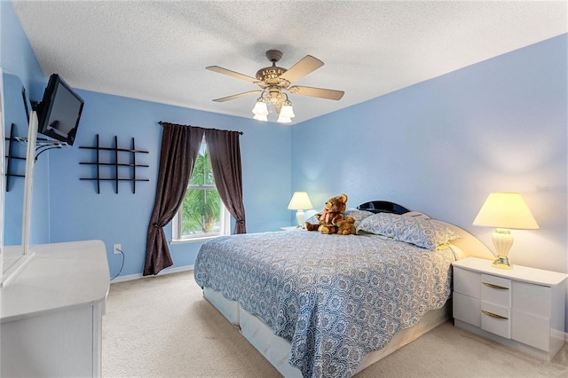 bedroom featuring a textured ceiling, ceiling fan, and light carpet