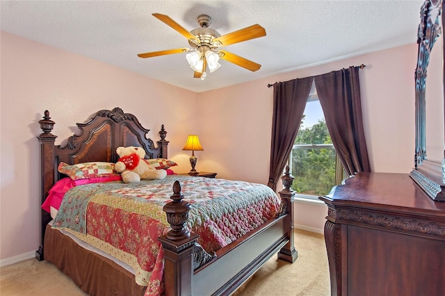 carpeted bedroom featuring ceiling fan and a textured ceiling