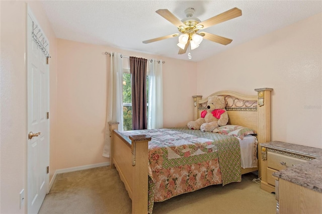 carpeted bedroom featuring ceiling fan and a textured ceiling