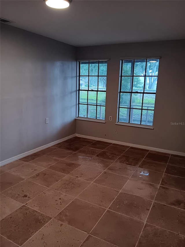 spare room featuring dark tile flooring