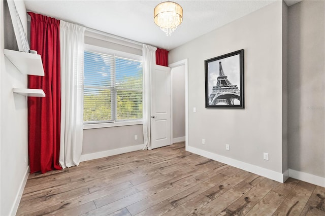 unfurnished room with hardwood / wood-style flooring