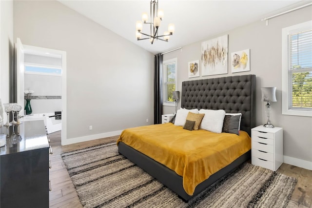 bedroom with vaulted ceiling, light wood-type flooring, and a notable chandelier