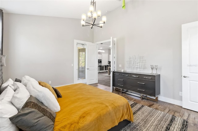 bedroom featuring high vaulted ceiling, dark hardwood / wood-style flooring, and a notable chandelier