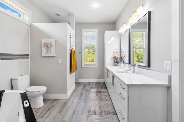 bathroom with wood-type flooring, a wealth of natural light, and toilet