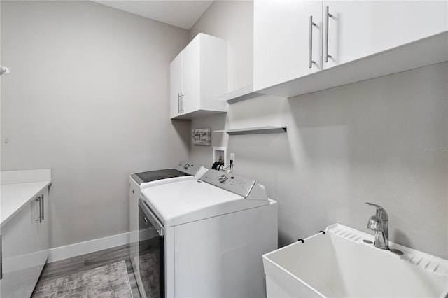 washroom featuring cabinets, sink, washer hookup, and washing machine and clothes dryer