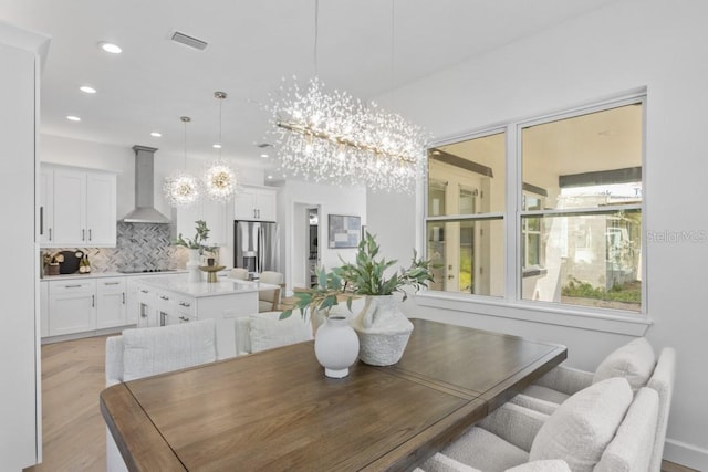 dining space featuring a notable chandelier and light hardwood / wood-style flooring