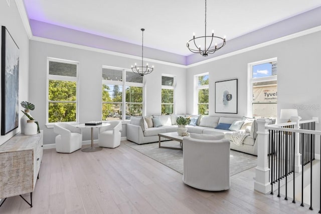 living room with a chandelier, light hardwood / wood-style flooring, and crown molding