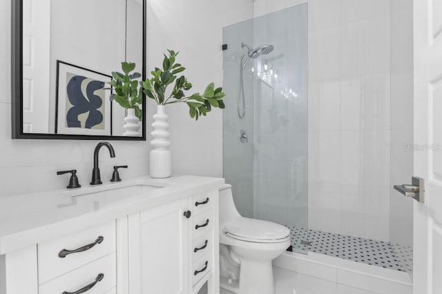 bathroom featuring tiled shower, vanity, and toilet