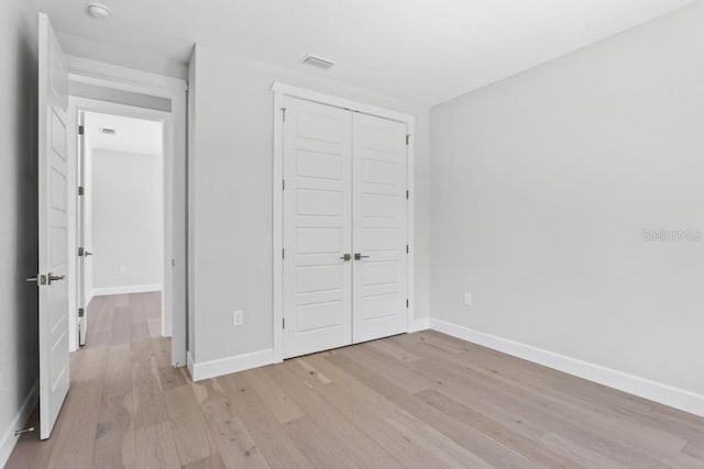 unfurnished bedroom with light hardwood / wood-style floors and a closet