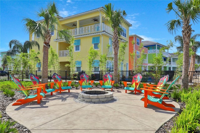 view of patio with a balcony and an outdoor fire pit